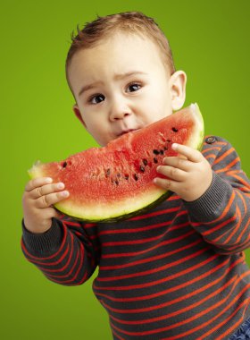 karpuz üzerinde yeşil backg tutan bir yakışıklı çocuk portresi