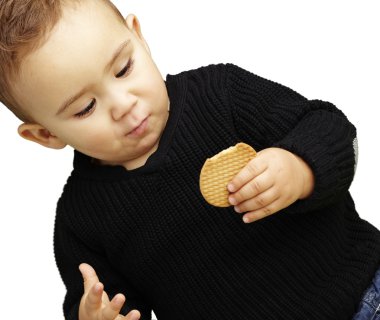 Beyaz backgr karşı bisküvi yeme yakışıklı çocuk portresi