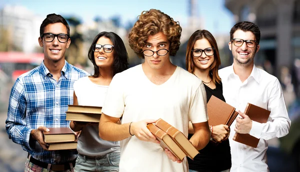 Retrato de jovens estudantes segurando livros na rua — Fotografia de Stock