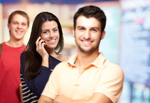 Young friends smiling and one girl talking on mobile over abstra — Stock Photo, Image
