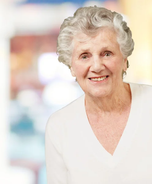 Портрет пожилой женщины, улыбающейся в помещении — стоковое фото