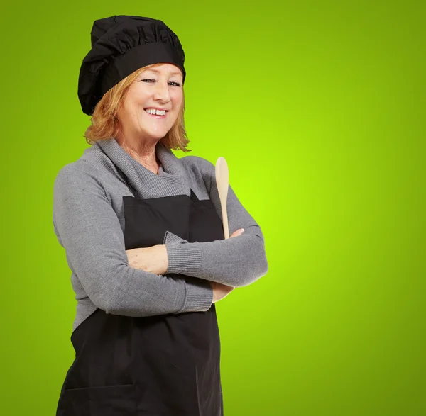 Kadın portresi cook giyen önlük üzerinde yeşil arka plan — Stok fotoğraf