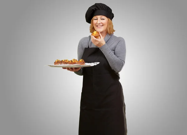 Portrét středního věku kuchaře žena držící chutné domácí — Stock fotografie