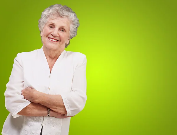 Porträt einer entzückenden Seniorin, die vor grünem Hintergrund steht — Stockfoto
