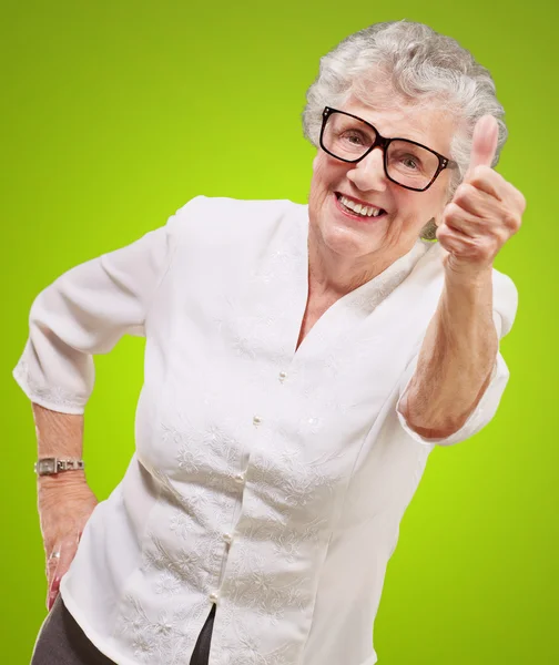 Retrato de mulher idosa adorável fazendo bom gesto sobre verde — Fotografia de Stock