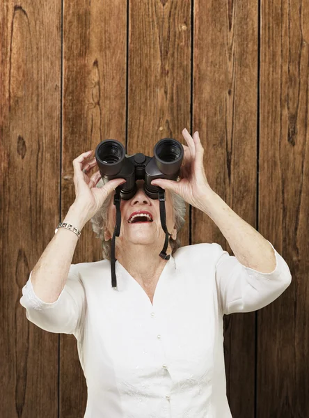 Portrét starší ženy dívá dalekohledem proti — Stock fotografie