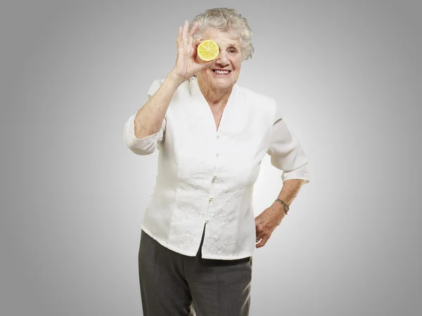 Muotokuva vanhempi nainen sitruuna silmän edessä yli gey — kuvapankkivalokuva