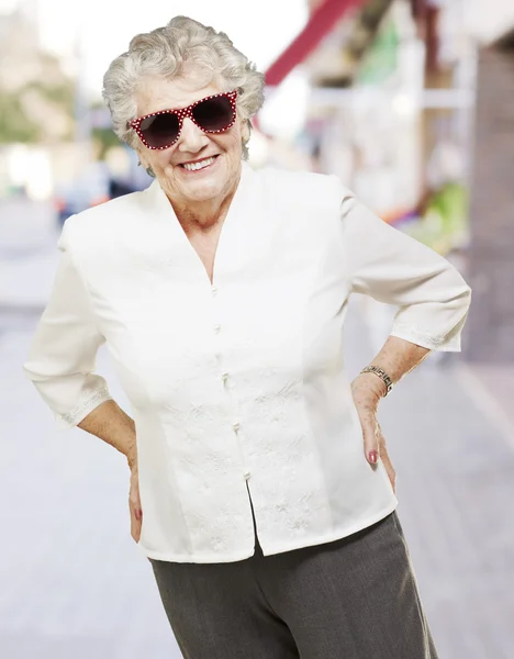 市内で年配の女性に立ってサングラスの肖像画 — ストック写真