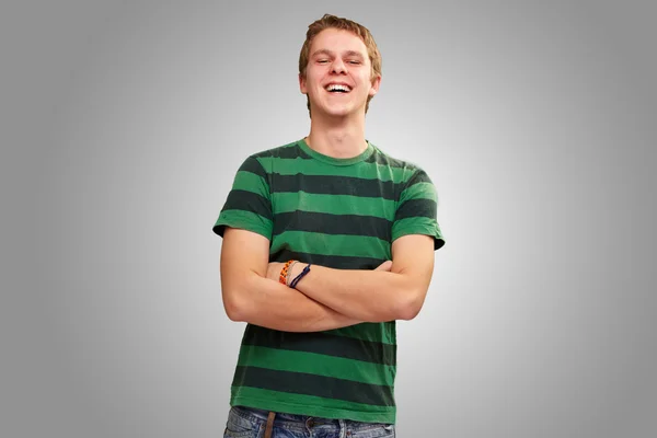 Portret van een jonge man die lacht over grijze achtergrond — Stockfoto