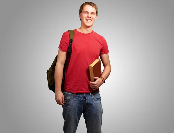 Ritratto di giovane studente che tiene libro e porta zaino ove — Foto Stock