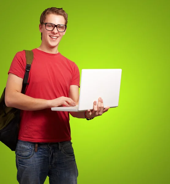 Portrét mladého muže drží notebook a nosit batoh nad g — Stock fotografie
