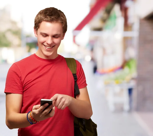 Retrato de jovem tocando tela móvel na rua — Fotografia de Stock