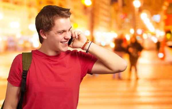 Портрет молодого чоловіка, який розмовляє на мобільному телефоні в нічному місті — стокове фото
