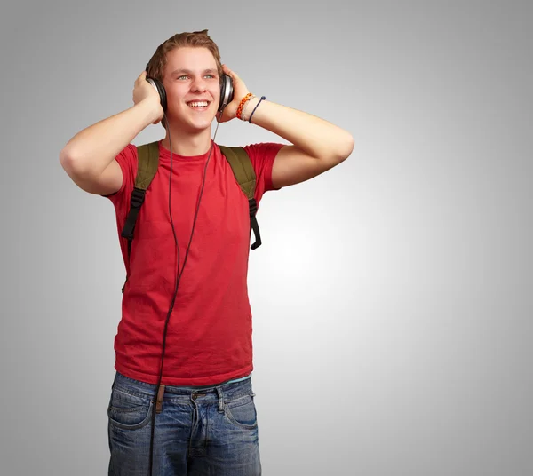 Retrato de jovem estudante alegre ouvindo música com headphon — Fotografia de Stock