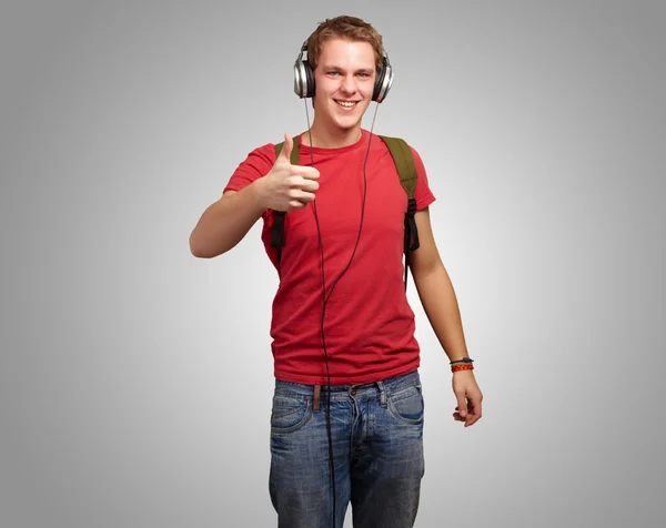 Retrato de jovem estudante alegre ouvindo música e gestos — Fotografia de Stock