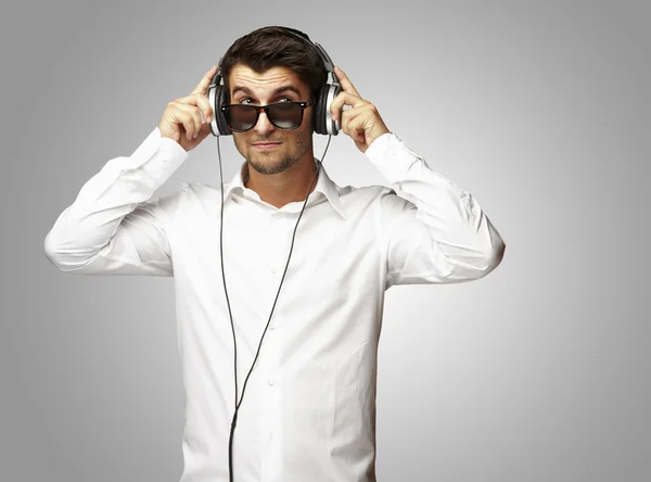 Portræt af unge mand lytter til musik ved hjælp af hovedtelefoner over g - Stock-foto