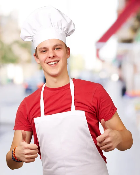 Retrato del joven cocinero haciendo símbolo de éxito en la calle —  Fotos de Stock