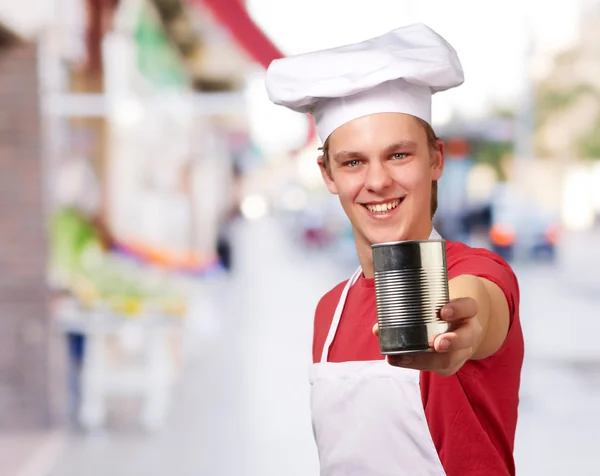 Retrato del joven cocinero sosteniendo una lata de metal en la calle — Foto de Stock