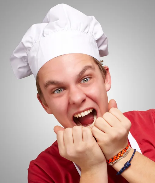 Gri arka plan üzerinde çığlık genç aşçı adam portresi — Stok fotoğraf