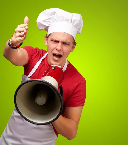 Ritratto di giovane cuoco che urla con megafono e gesturina — Foto Stock