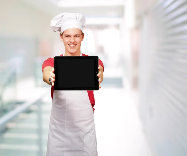 Портрет молодого повара с цифровой табличкой у входа — стоковое фото
