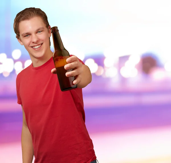 Genç adam bira tutarak karşı arka plan portresi — Stok fotoğraf