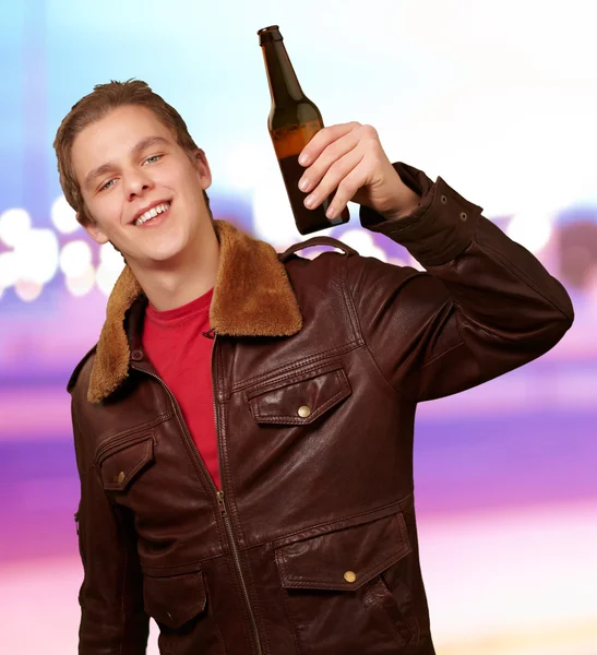 Portrét mladého muže drží pivo abstraktní pozadí — Stock fotografie