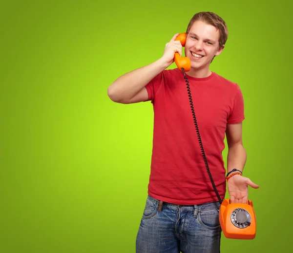 Портрет молодого чоловіка, що розмовляє зі старовинним телефоном над зеленим — стокове фото