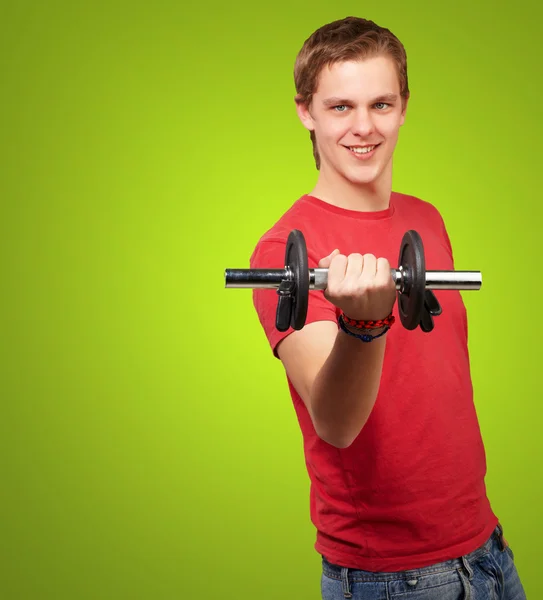 Porträtt av ung man med vikter över grön bakgrund — Stockfoto