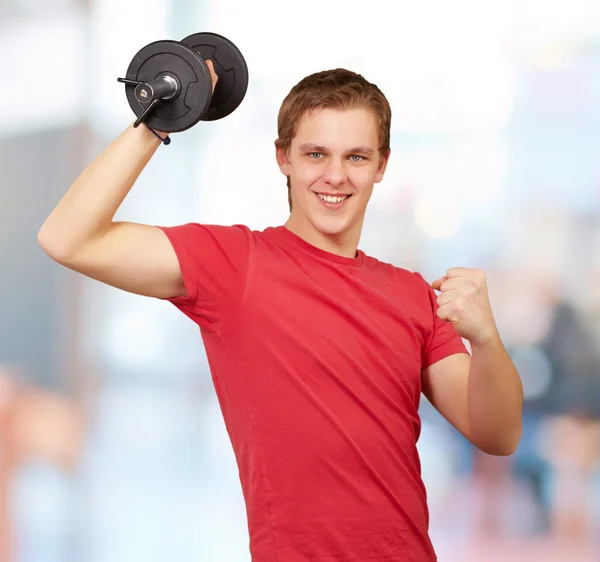 Jovem fazendo fitness com pesos indoor — Fotografia de Stock