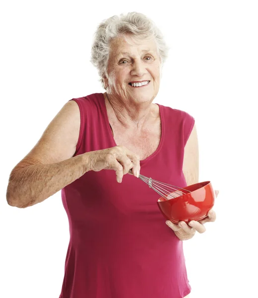 Старшая женщина бьет яйца — стоковое фото