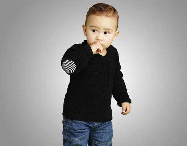 Retrato de un niño adorable pensando sobre un fondo gris — Foto de Stock