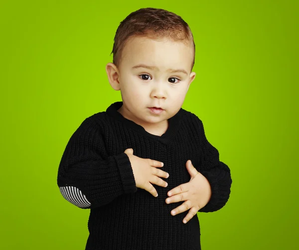 Portrait of adorable kid touching his stomach against a green ba — Stock Photo, Image