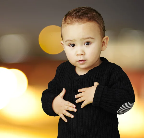 Ritratto di adorabile bambino che si tocca lo stomaco in città di notte — Foto Stock