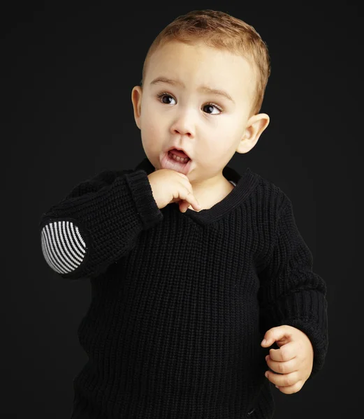 Retrato de un niño adorable y reflexivo sobre un fondo negro —  Fotos de Stock