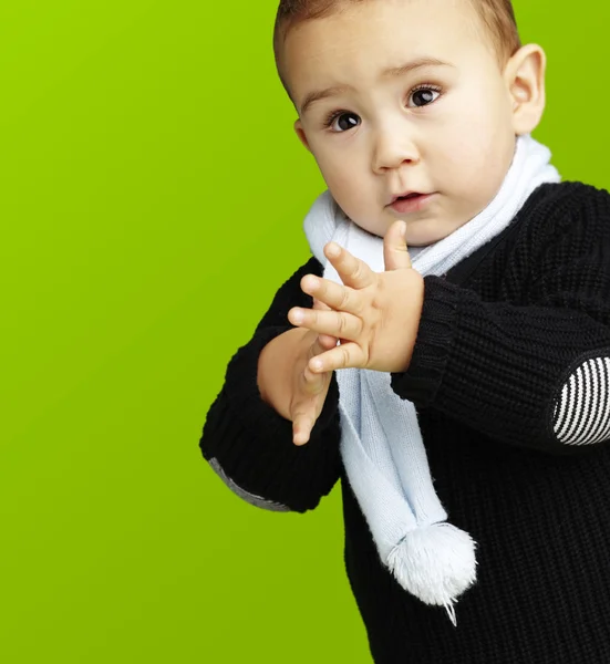 Портрет очаровательного ребенка, хлопающего в ладоши на зеленом фоне — стоковое фото