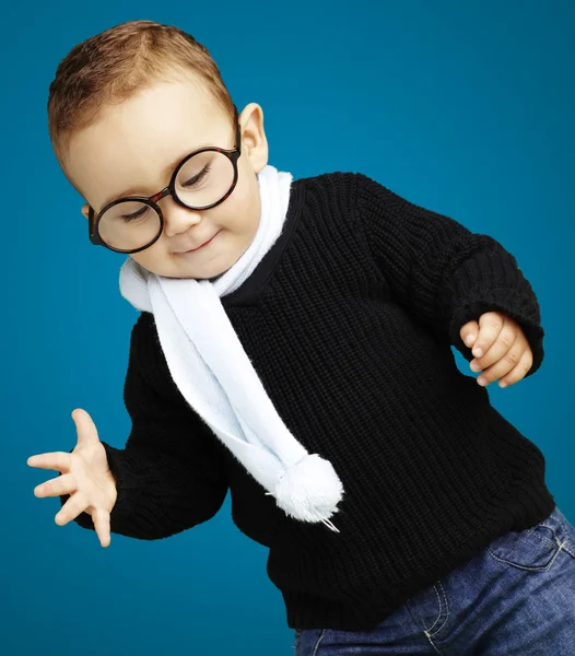 Retrato de un niño con gafas mirando hacia abajo contra una espalda azul — Foto de Stock