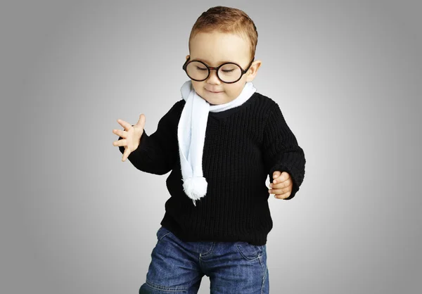 Πορτρέτο του παιδιού που φοράει γυαλιά, κοιτάζοντας προς τα κάτω κατά ένα γκρι πίσω — Φωτογραφία Αρχείου