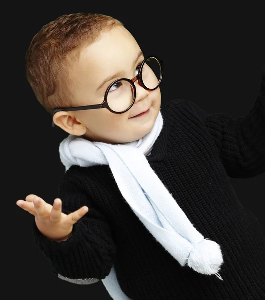 Portret van schattige jongen gebaren twijfel tegen een zwarte backgro — Stockfoto