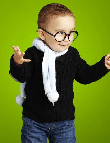 Портрет очаровательного ребенка, показывающего сомнение против зеленого бэкгро — стоковое фото