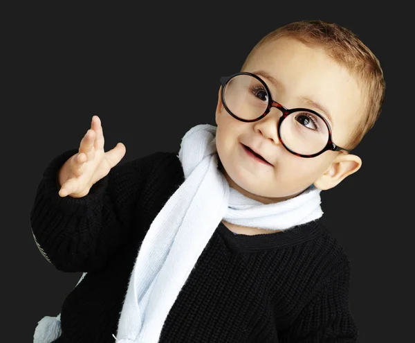 Porträt eines entzückenden Kindes, das Zweifel vor schwarzem Hintergrund gestikuliert — Stockfoto