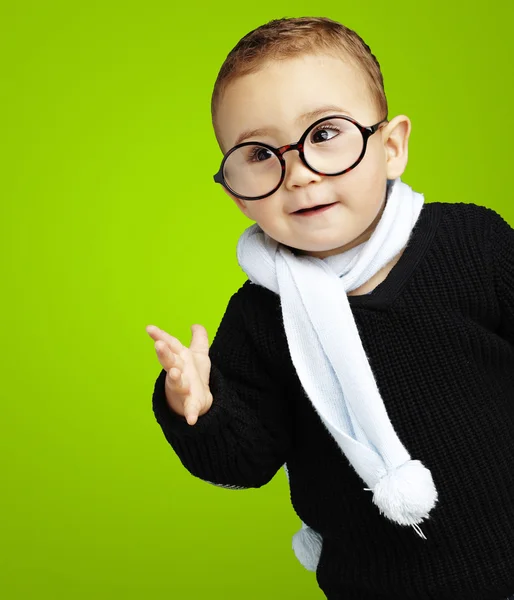 Portrét rozkošný dítě pochybností směřují proti zelené backgro — Stock fotografie