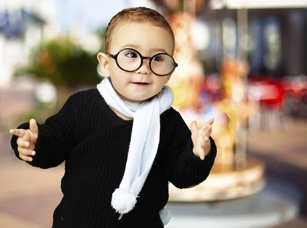 Retrato de un niño adorable con gafas haciendo gestos de duda contra —  Fotos de Stock
