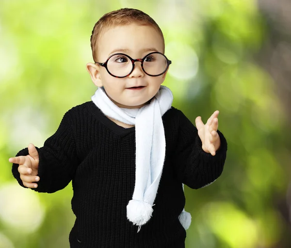 Ritratto di adorabile bambino che indossa occhiali gesticolando il dubbio contro — Foto Stock
