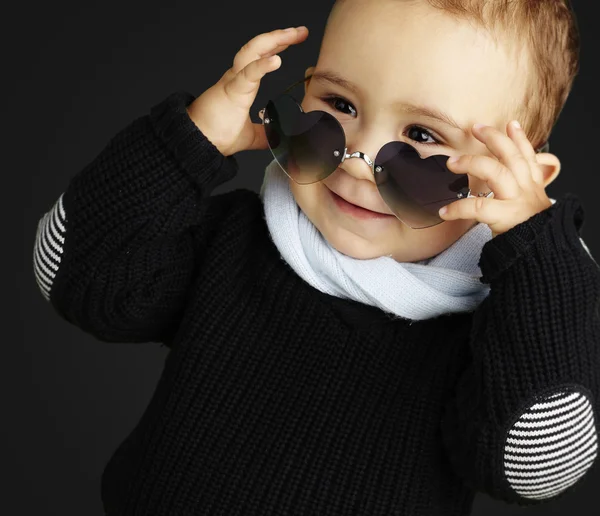 Portrait of funny kid wearing heart sunglasses against a black b — Stock Photo, Image