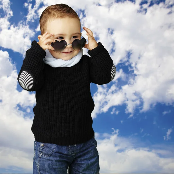 Bulutlu karşı kalp güneş gözlüğü takmış komik çocuk portresi — Stok fotoğraf