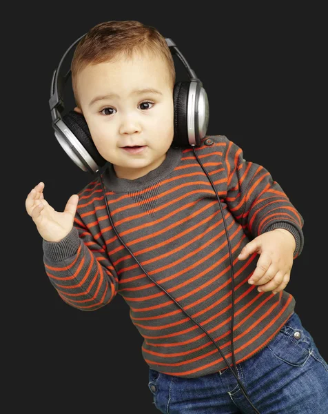 Portrait d'adorable enfant avec écouteurs écoutant de la musique agai — Photo