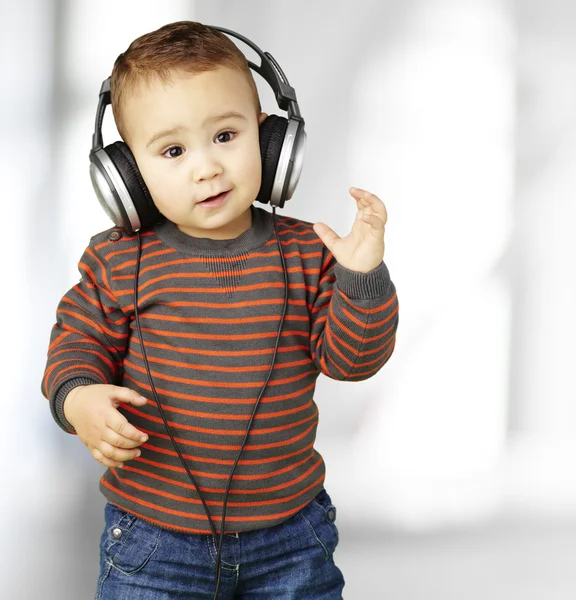 Portrait of adorable kid with headphones listening to music indo — Stock Photo, Image