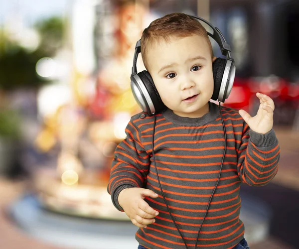 可爱的孩子，戴着耳机听音乐反对的肖像 — 图库照片