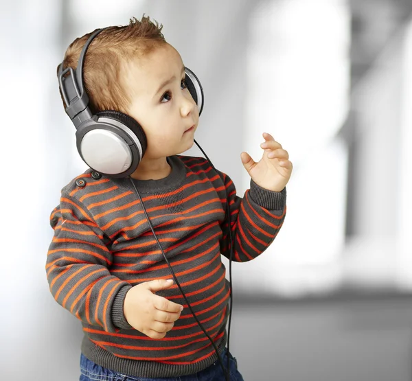 Retrato de niño adorable con auriculares escuchando música indo — Foto de Stock